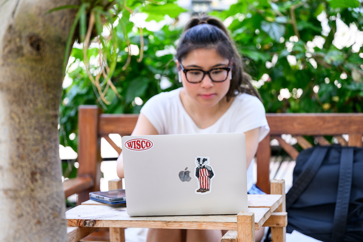 Student sitting at a table with a laptop in front of them