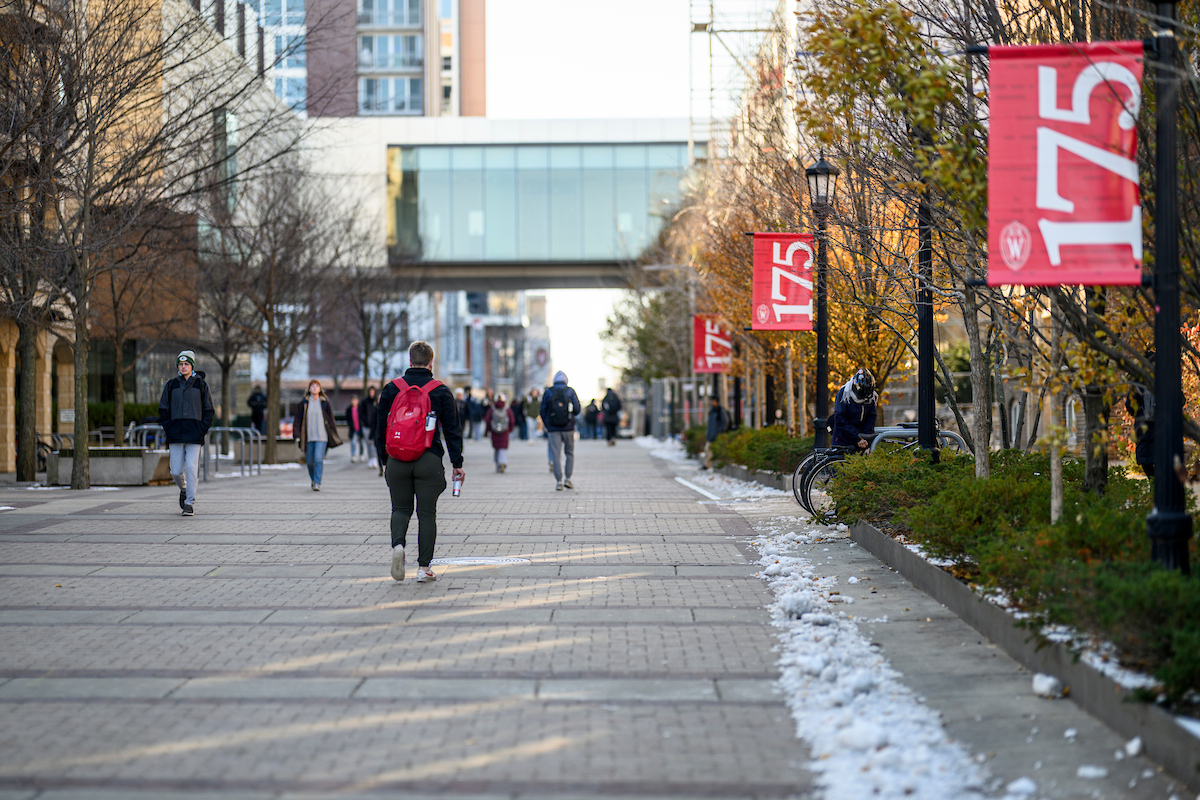 Paved walkway with posts every few feet with red flags that say 175